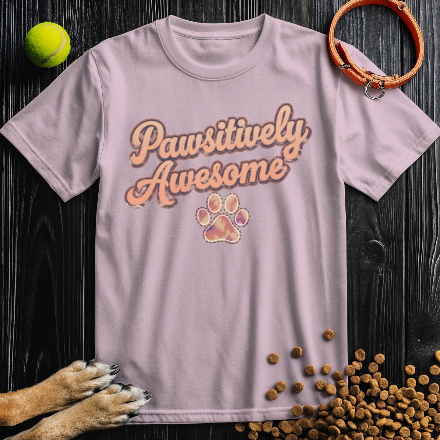 Light pink dog theme t-shirt with 'Pawsitively Awesome' text and paw design, made from 100% cotton. Unisex fit for dog enthusiasts.