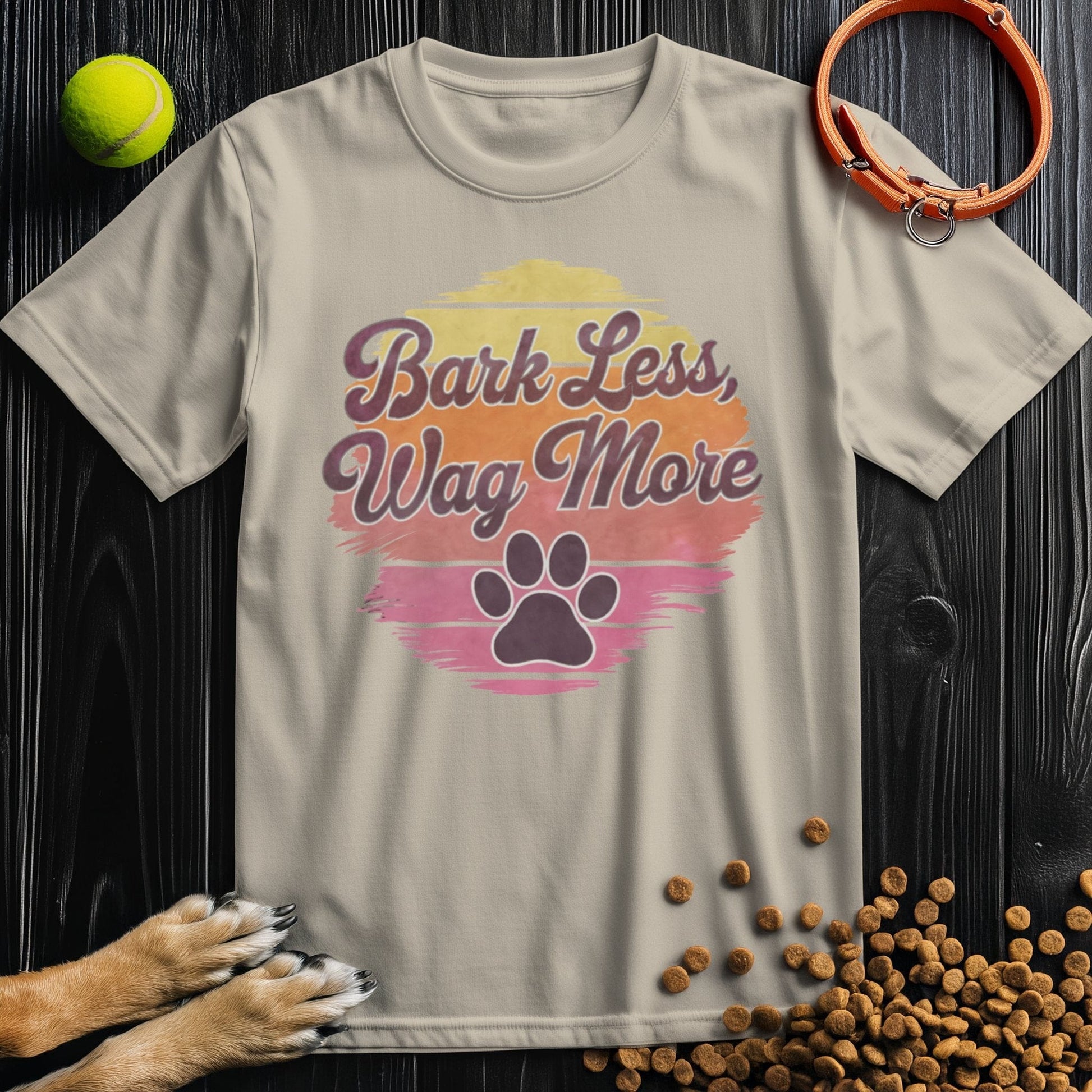 Beige Bark Less, Wag More T-Shirt featuring a retro paw print graphic. 100% cotton, unisex fit for dog lovers and casual outfits.
