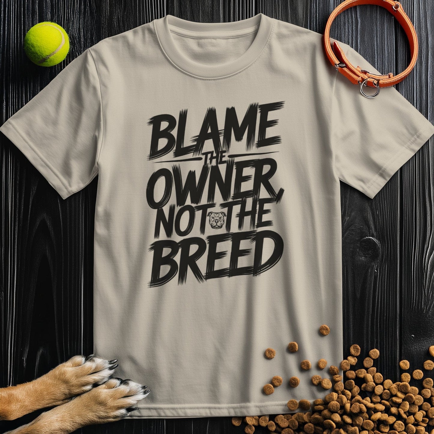 Beige dog lovers' t-shirt with bold 'Blame the Owner Not the Breed' slogan in black. Made from 100% cotton, ideal for pet advocates.