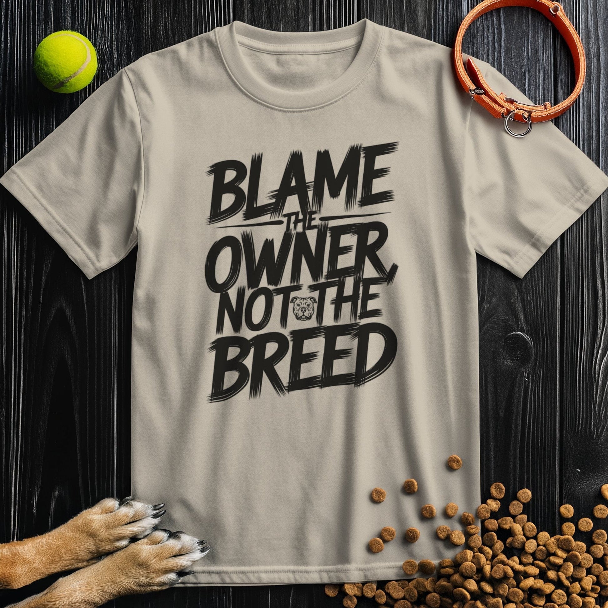 Beige dog lovers' t-shirt with bold 'Blame the Owner Not the Breed' slogan in black. Made from 100% cotton, ideal for pet advocates.