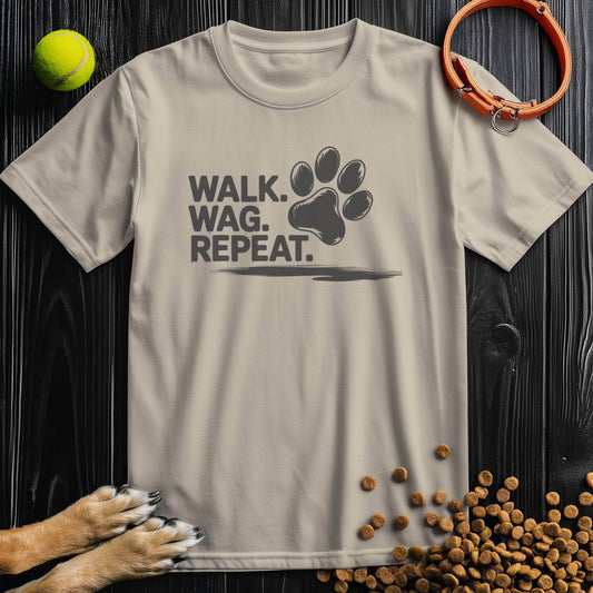 Beige Walk Wag Repeat T-Shirt for dog lovers with black paw print design, 100% cotton, laid flat with dog accessories.